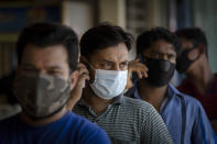 Foreign workers wearing face masks wait for new coronavirus testing at a wet market in Kuala Lumpur, Malaysia Tuesday, May 5, 2020. Malaysia's government says all foreign workers must undergo mandatory virus testing as many business sectors reopen in parts of the country for the first time since a partial virus lockdown began March 18. A senior official says the government has decided to make it compulsory for foreign workers to take virus tests after cases rose over the weekend including a new cluster involving foreign workers at a construction site. (AP Photo/Vincent Thian)