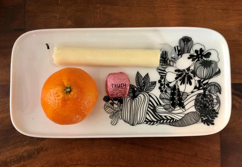 A tangerine with string cheese and a Dove Promise square.  (Heather Martin)