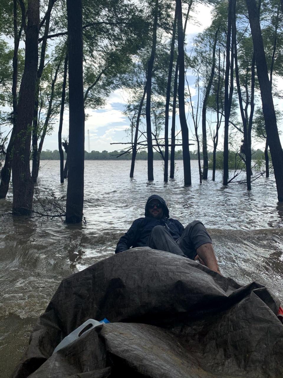 Connor Sheets tries to avoid getting wet in a beached canoe on the banks of the Mississippi River