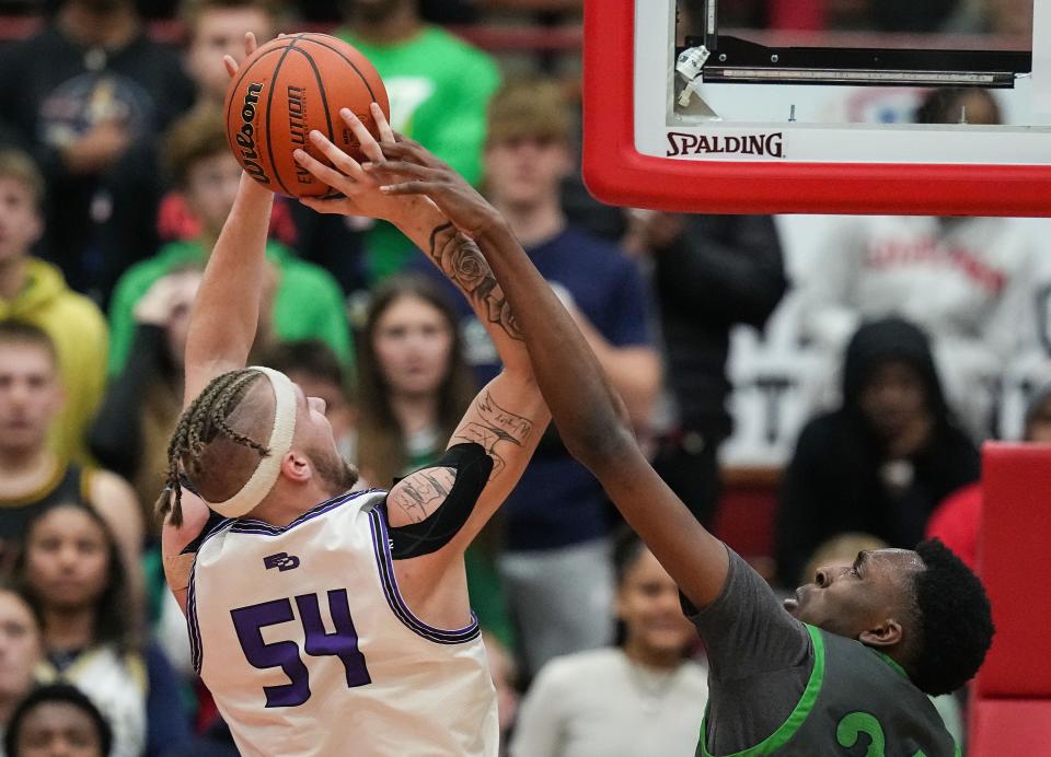 Ben Davis Giants center Zane Doughty (54) reaches for a lay-up against Cathedral Fighting Irish Xavier Booker (34) on Saturday, March 11, 2023 at Southport High School in Indianapolis. The Ben Davis Giants defeated the Cathedral Fighting Irish, 63-53, for the IHSAA Class 4A regional championship. 