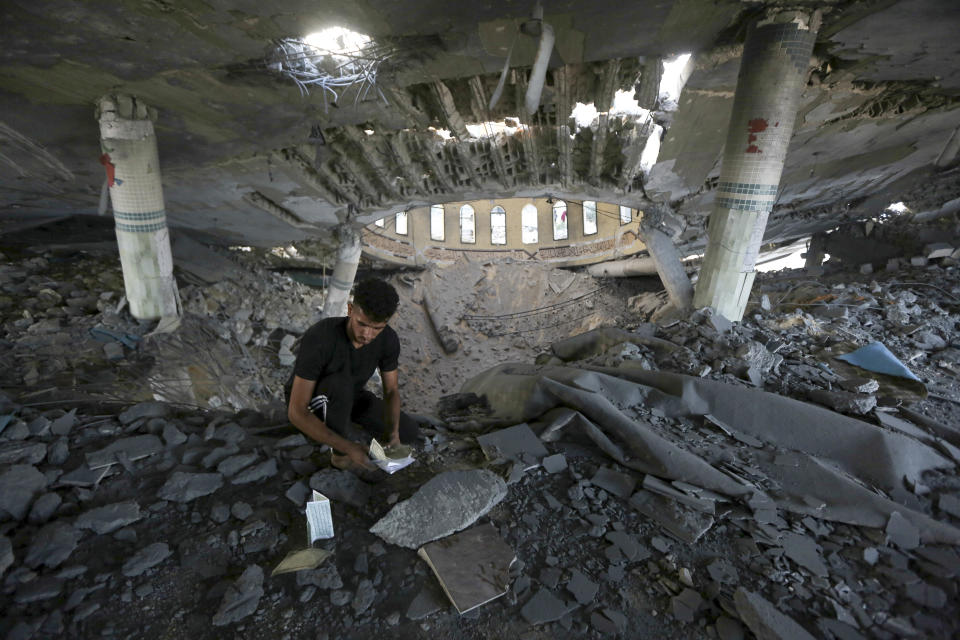 FILE - A man looks at damaged books inside a mosque destroyed in an Israeli air strike in Khan Younis, Gaza Strip, Sunday, Oct.8, 2023. The Hamas militants broke out of the blockaded Gaza Strip and rampaged through nearby Israeli communities, taking captives, while Israel's retaliation strikes leveled buildings in Gaza. (AP Photo/Yousef Masoud, File)