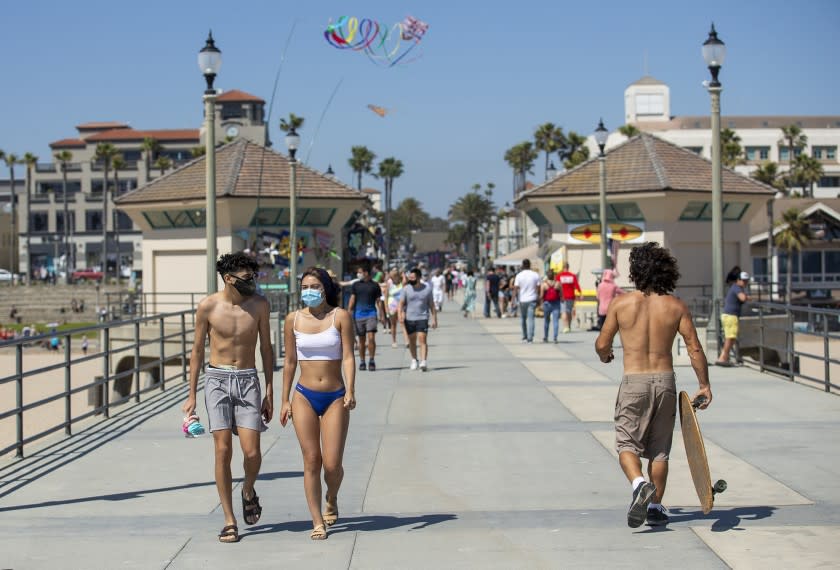 People walk along the Huntington Beach Pier on May 26, 2020, after it opened for the first time since March. (Scott Smeltzer / Times Community News)