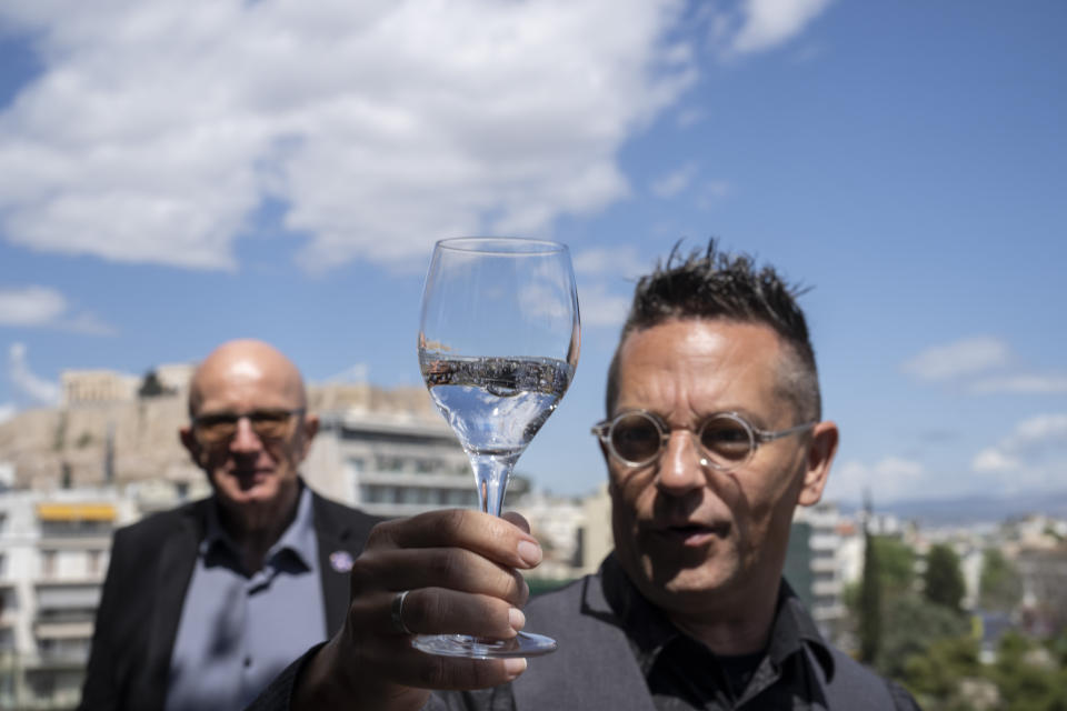 Mineral water sommelier Martin Riese, right, examines a glass of fine water during an International Water Tasting Competition, in Athens, Greece, on Wednesday, April 26, 2023, accompanied by Michael Mascha, founder of the Fine Water Society. (AP Photo/Petros Giannakouris)