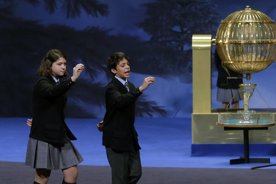 School children sing out the number of the top prize of Spain's Christmas lottery known as 'El Gordo' or 'The Fat One', as they hold lottery balls, in Madrid, Sunday Dec. 22, 2013. Millions of Spaniards are glued to television as the country's cherished Christmas lottery, the world's richest, distributes a bounty of 2.5 billion euros ($3.4 billion) in prize money to winning ticket owners. The draw is so popular that most of Spain's 46 million inhabitants traditionally watch some part of it live in the hope that the school children singing out winning numbers will call out their ticket. The top prize, known as "El Gordo" (The Fat One), gives lucky winners 400,000 euros per ticket, while the second-best number nets 125,000 euros. Unlike lotteries that offer one large jackpot, Spain's yuletide draw sprinkles winnings of values lower than El Gordo on thousands of ticket holders. (AP Photo/Andres Kudacki)