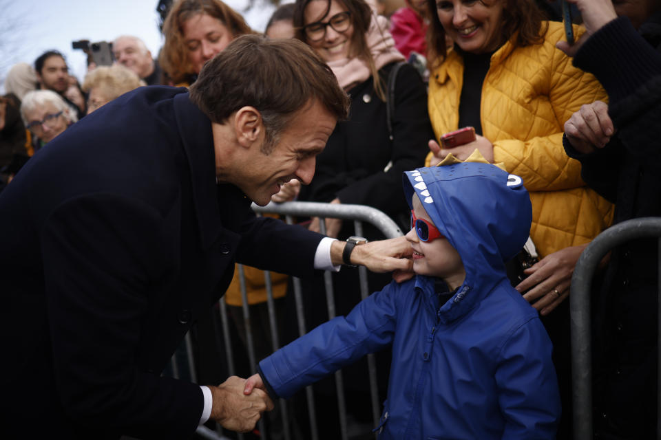 French President Emmanuel Macron greets a child as he meets with members of the public during a visit after the storm Ciaran in Daoulas, Brittany, Friday, Nov.3 2023. The storm receded in northern France and the Atlantic coast on Friday, but heavy rains continued in some regions (Yoan Valat, Pool via AP)