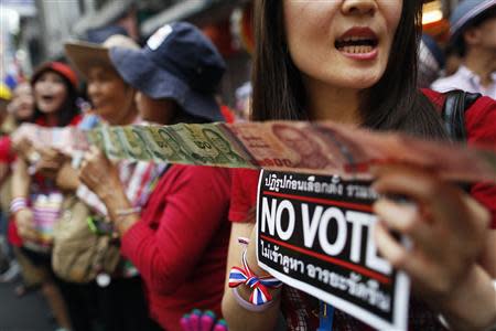 Anti-government protesters hold "No Vote" stickers and Thai baht banknotes to donate to their leader during a march through Chinatown in Bangkok February 1, 2014. REUTERS/Damir Sagolj