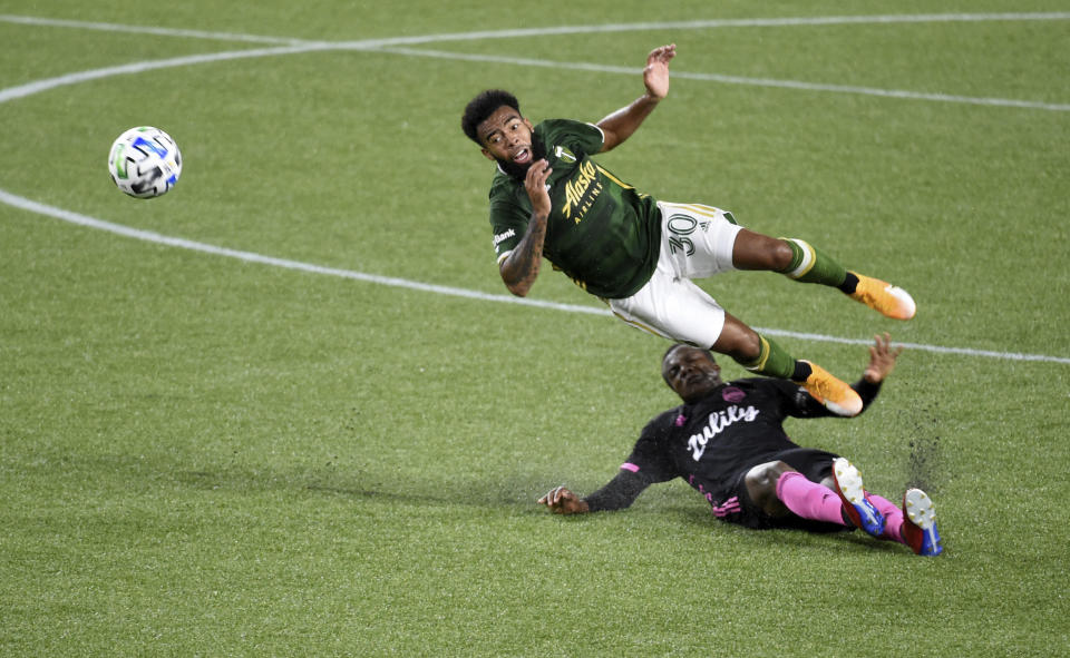 Portland Timbers midfielder Eryk Williamson, left, is upended by Seattle Sounders defender Nouhou Tolo during the first half of an MLS soccer match in Portland, Ore., Wednesday, Sept. 23, 2020. (AP Photo/Steve Dykes)