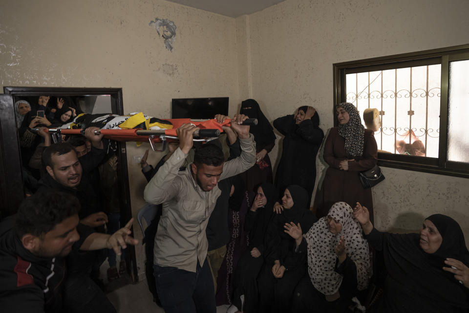 Relatives attend the funeral of Khalil Bahtini, the Islamic Jihad militant group's commander for the northern Gaza Strip, his wife and son, who were killed in an Israeli airstrike at their family home in Gaza City, Tuesday, May 9, 2023. Bahtini was among three senior Islamic Jihad commanders killed in targeted airstrikes early Tuesday. Palestinian health officials said at least 10 others were killed, including wives of two of the militants, several of their children and others nearby. (AP Photo/Fatima Shbair)