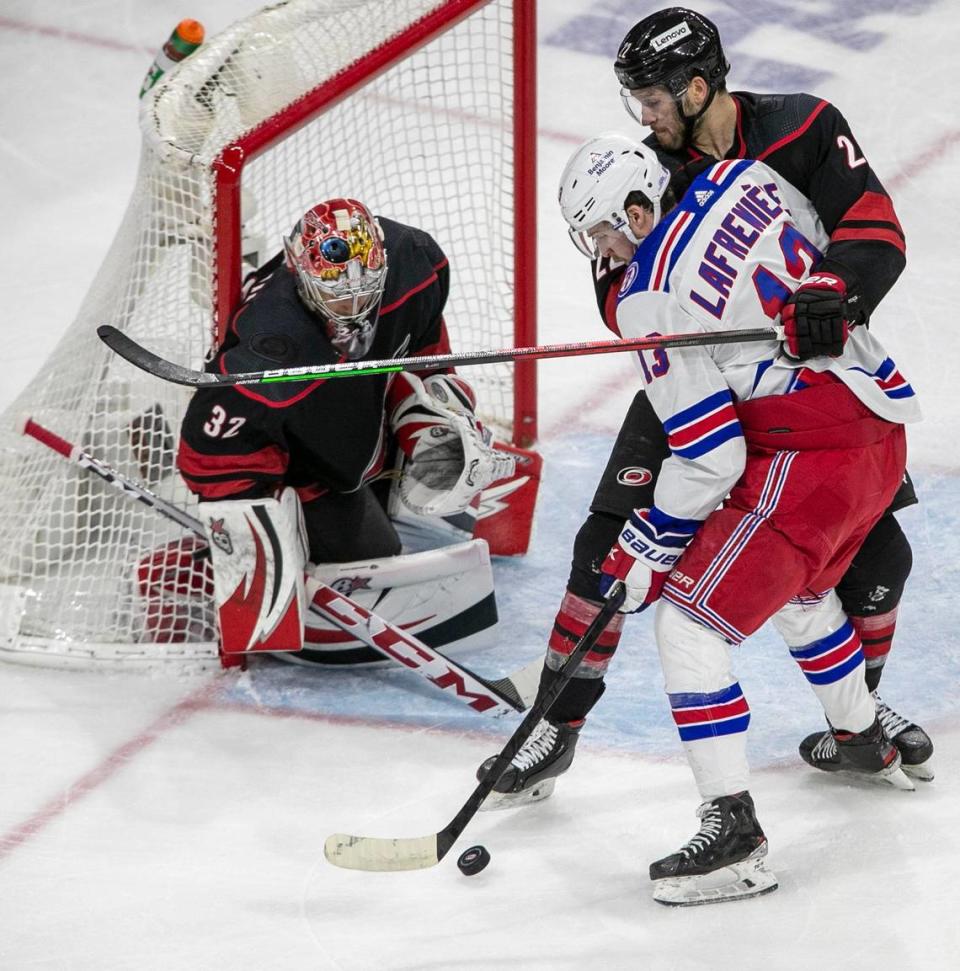 Carolina Hurricanes Brett Pesce (22) defends New York Rangers Alexis Lafreniere (13) in front of the Hurricanes goalie Antii Raanta (32) in the second period on Friday, May 20, 2022 during game two of the Stanley Cup second round at PNC Arena in Raleigh, N.C.