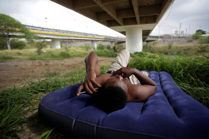 A migrant from Haiti rests under the Matamoros-Brownsville International Bridge as local authorities prepare to respond to the coronavirus disease (COVID-19) outbreak, in Matamoros