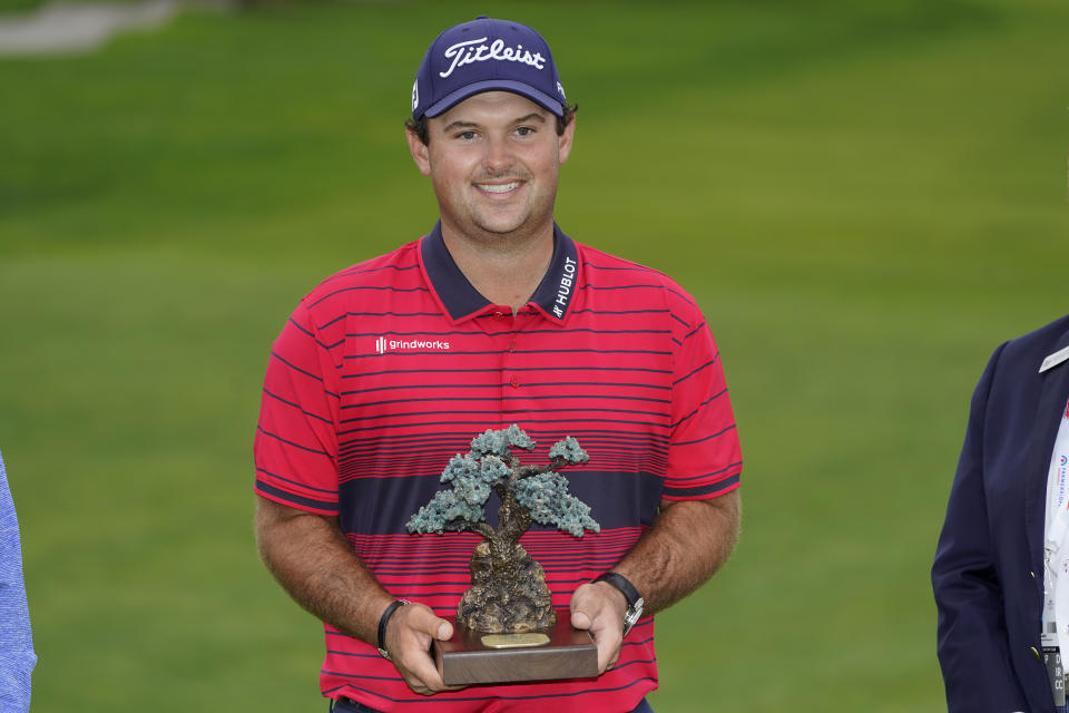 Patrick Reed stands on the South Course while holding his trophy for winning the Farmers Insurance Open golf tournament at Torrey Pines, Sunday, Jan. 31, 2021, in San Diego. (AP Photo/Gregory Bull)