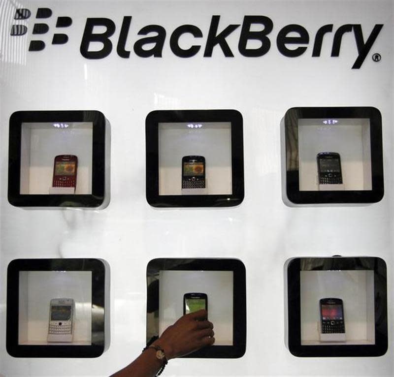 A salesman arranges a BlackBerry mobile phone inside a display box at a showroom in the western Indian city of Ahmedabad October 13, 2011. REUTERS/Amit Dave