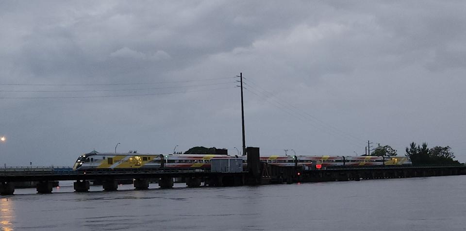 A Brightline train passes southbound at 6:48 p.m. Sept. 23, 2023 after a barge struck a fender of the railroad drawbridge.