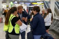 Passengers are seen at Thomas Cook check-in points at Mallorca Airport as an announcement is expected on the tour operator, in Palma de Mallorca