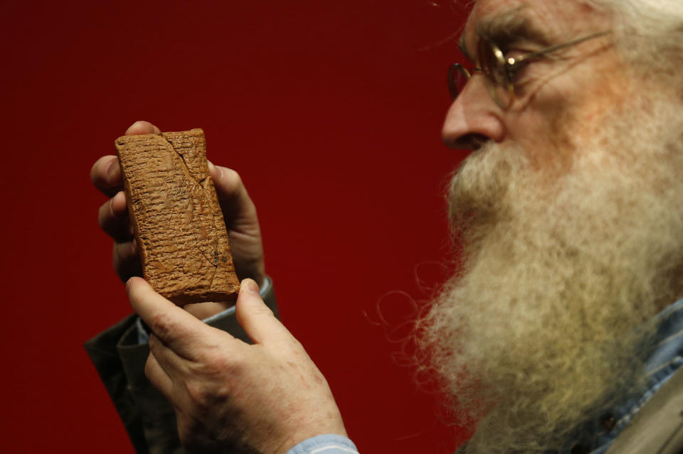 Irving Finkel, curator in charge of cuneiform clay tablets at the British Museum, poses with the 4000 year old clay tablet containing the story of the Ark and the flood during the launch of his book 'The Ark Before Noah' at the British Museum in London, Friday Jan. 24, 2014. The book tells how he decoded the story of the Flood and offers a new understanding of the Old Testament's central narratives and how the flood story entered into it. (AP Photo/Sang Tan)