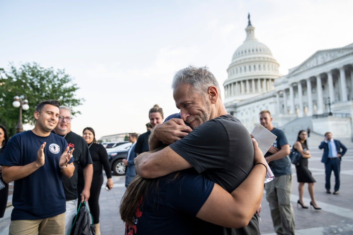 Comedian and activist Jon Stewart hugs Rosie Torres, wife of veteran Le Roy Torres who suffers from illnesses related to his exposure to burn pits in Iraq, after the Senate passed the PACT Act at the US Capitol August 2, 2022 (Getty Images)