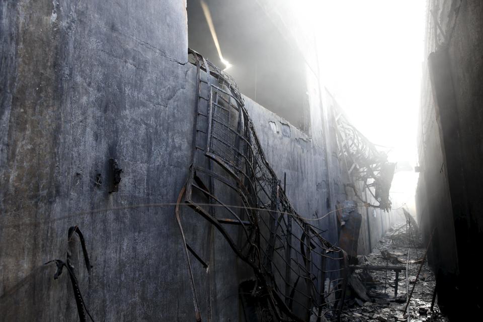 Burnt steel window grills are pictured hanging, where workers escaped as a fire razed a slipper factory in Valenzuela