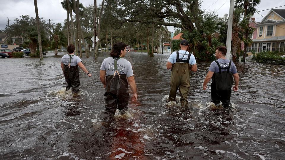 Members of the Daytona Beach Fire Department walk through floodwaters searching for people that may need help after Hurricane Nicole came ashore on November 10, 2022, in Daytona Beach, Florida. Nicole came ashore as a Category 1 hurricane before weakening to a tropical storm as it moved across the state.