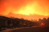 <p>Fire trucks monitor a fire that threatens the Oakmont community along Highway 12 in Santa Rosa on Oct. 13, 2017. The retirement community had been evacuated on the second day of the Santa Rosa fire. (Photo : Genaro Molina/Los Angeles Times via Getty Images) </p>