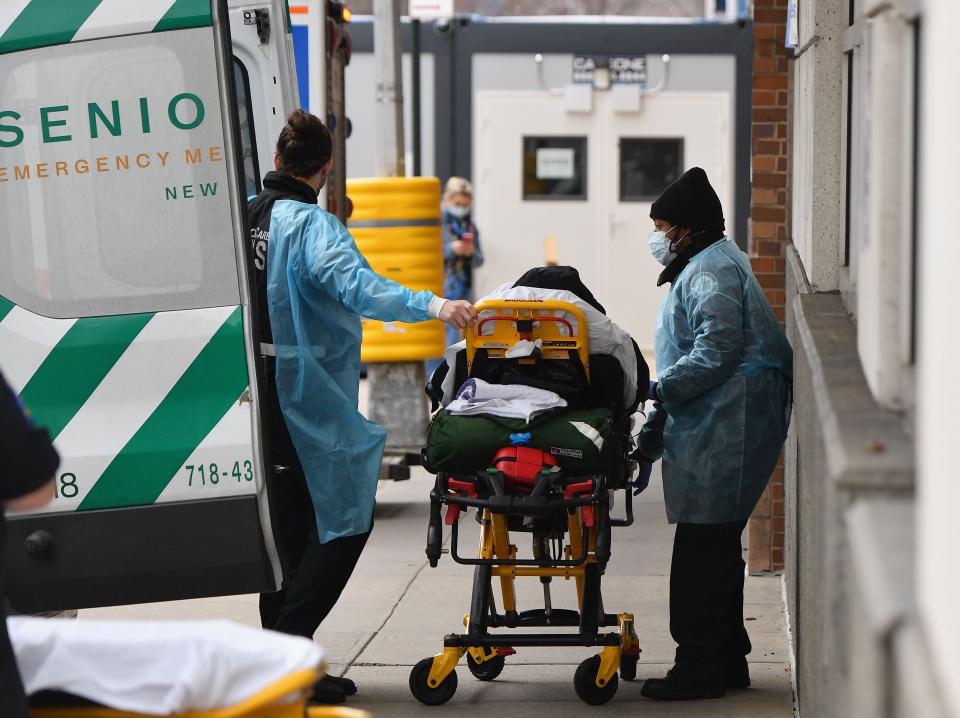 A patient on trolley is transferred from ambulance to hospital.