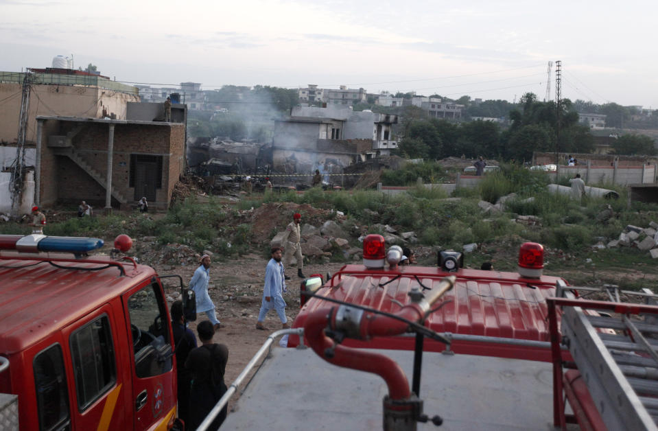 Pakistan army troops cordon-off surrounding area of plane crash site in Rawalpindi, Pakistan, Tuesday, July 30, 2019. A small Pakistani military plane crashed into a residential area near the garrison city of Rawalpindi before dawn, killing some people, officials said. (AP Photo/Anjum Naveed)