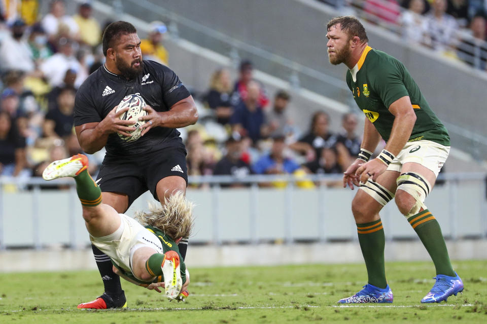 New Zealand's Nepo Laulala is tackled by South Africa's Faf de Klerk as South Africa's Duane Vermeulen, right, watches during the Rugby Championship test match between the Springboks and the All Blacks in Townsville, Australia, Saturday, Sept. 25, 2021. (AP Photo/Tertius Pickard)