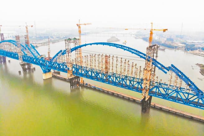 12月22日，由中鐵六局承建的南沙港鐵路跨洪奇瀝水道特大橋主橋小里程柔性拱順利提升合龍。（繆曉劍攝）