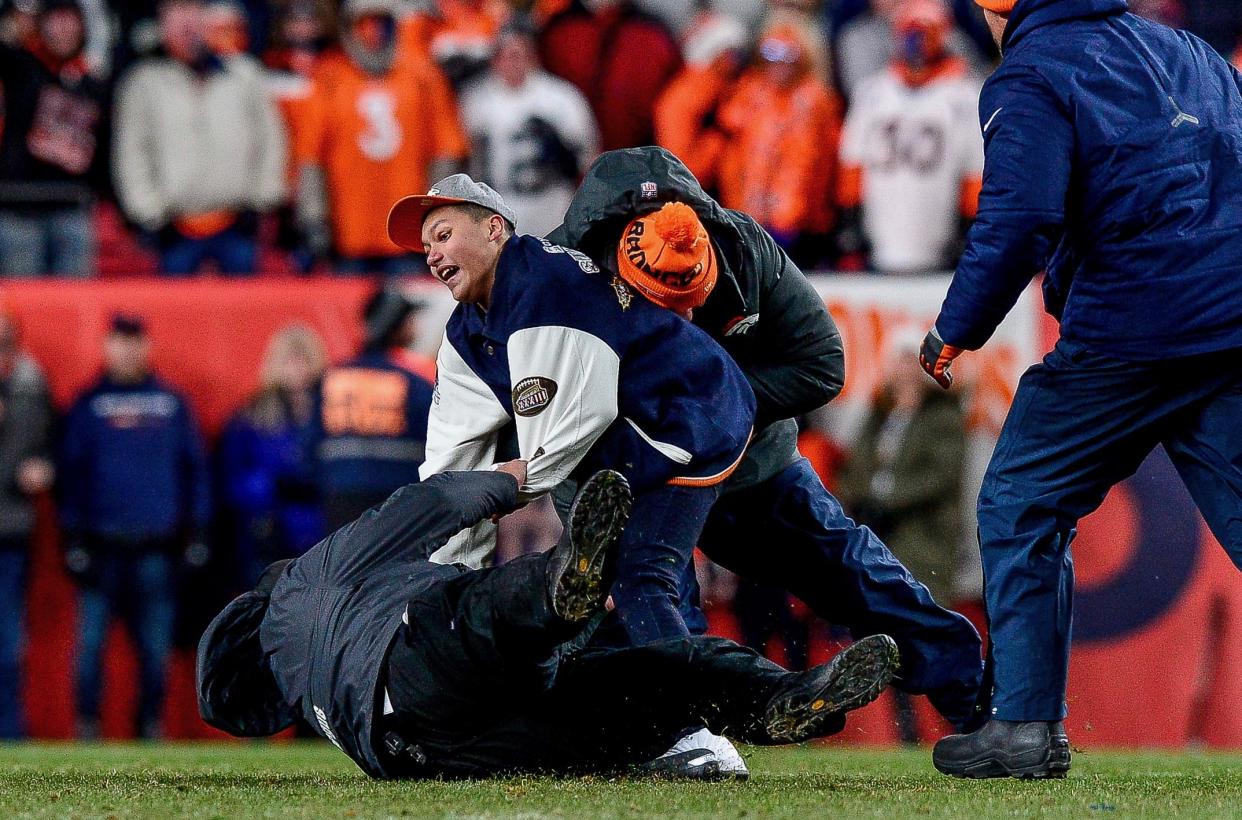 A security guard suffered a serious ankle injury after a fan ran onto the field in Denver. (Dustin Bradford/Getty Images)