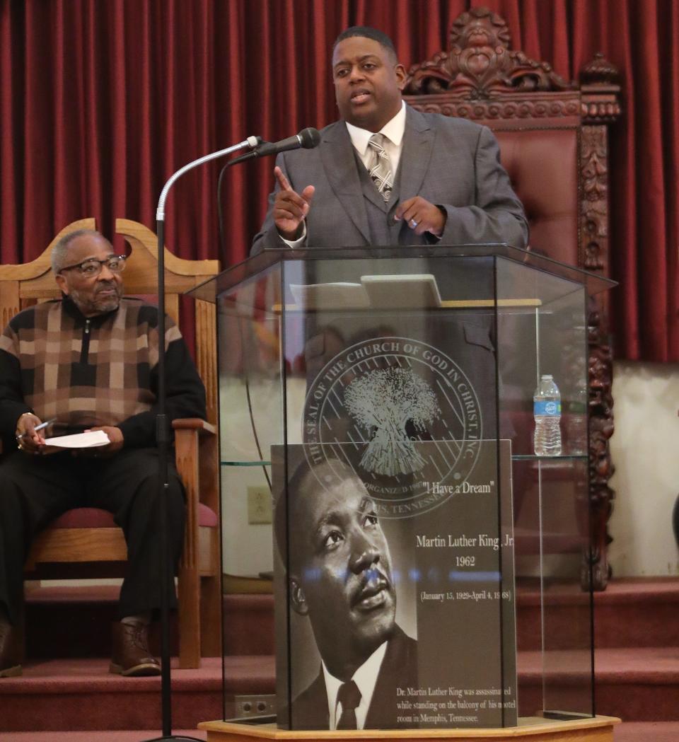 Guest speaker Pastor Aaron Hill Sr., at lectern, of Tabernacle Baptist Church, speaks as Pastor Bobby Williams, left, looks on during the annual Dr. Martin Luther King Jr. Observance Day Celebration on Sunday, Jan. 14, 2024, at the Temple of Faith Church of God in Christ.