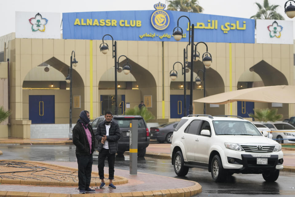 People stand outside Al Nassr soccer club grounds in Riyadh, Saudi Arabia, Monday, Jan 2, 2023. Cristiano Ronaldo completed a lucrative move to Saudi Arabian club Al Nassr on Friday in a deal that is a landmark moment for Middle Eastern soccer but will see one of Europe's biggest stars disappear from the sport's elite stage. (AP Photo/Amr Nabil)