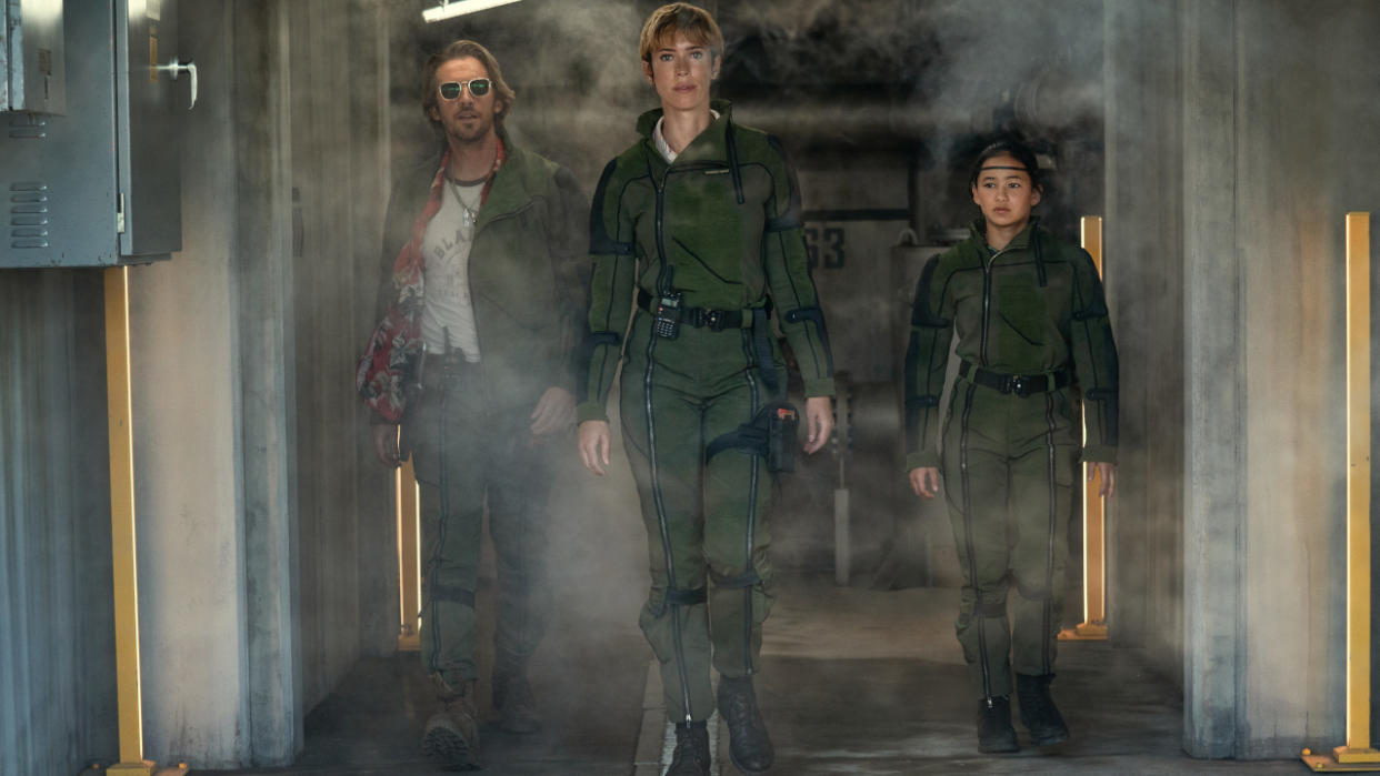  Dan Stevens, Rebecca Hall, and Kaylee Hottle walking down a hallway together in formation in Godzilla x Kong: The New Empire. 