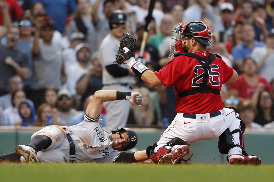 Boston Red Sox's Kevin Plawecki (25) makes the out on New York Yankees' Brett Gardner trying to score on a fielders choice during the sixth inning of a baseball game, Saturday, Sept. 25, 2021, in Boston. (AP Photo/Michael Dwyer)