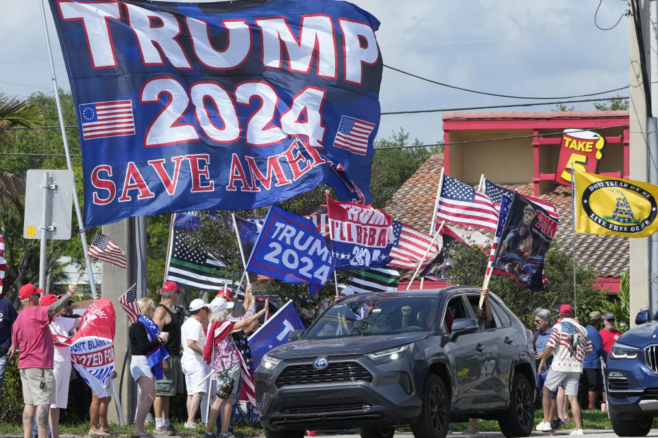 Supporters of former President Donald Trump chant and wave flags at a rally, Monday, April 3, 2023, in West Palm Beach, Fla. (AP Photo/Wilfredo Lee)