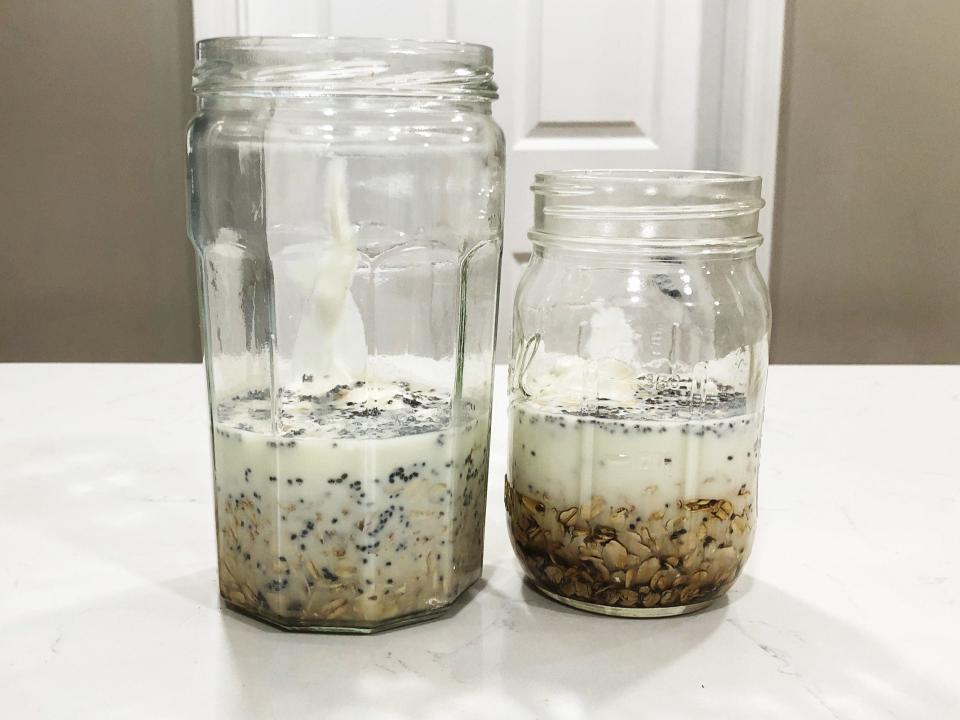 Two mason jars with a mixture of ingredients for overnight oats inside. The jar on the left is taller than the jar on the right.