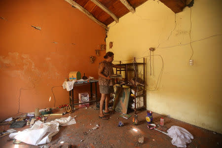 Felina, 50, an indigenous Zapotec transgender woman also know as Muxe, holds her belongings inside her house destroyed after an earthquake that struck on the southern coast of Mexico late on Thursday, in Juchitan, Mexico, September 10, 2017. Picture taken, September 10, 2017. REUTERS/Edgard Garrido