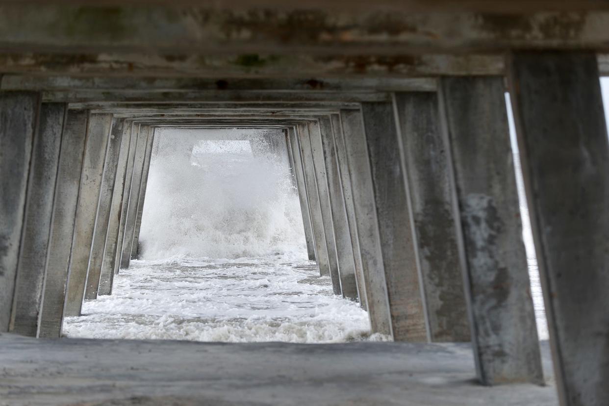 Waves crash under the pier on Wednesday as the effects of Hurricane Ian reached Tybee Island.