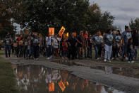 FILE - People hold up pictures of Eliahna Torres as they parade in a large group through Hillcrest Memorial Cemetery in Uvalde, Texas, Nov. 2, 2022, to visit the gravesites of Robb Elementary massacre victims and observe Día de los Muertos together. Sandra Torres, the mother of Eliahna Torres who was one of 19 children and two teachers killed in the school shooting in Uvalde, filed a federal lawsuit on Monday, Nov. 28, against the police, the school district and the maker of the gun used in the massacre. (Sam Owens/The San Antonio Express-News via AP, File)