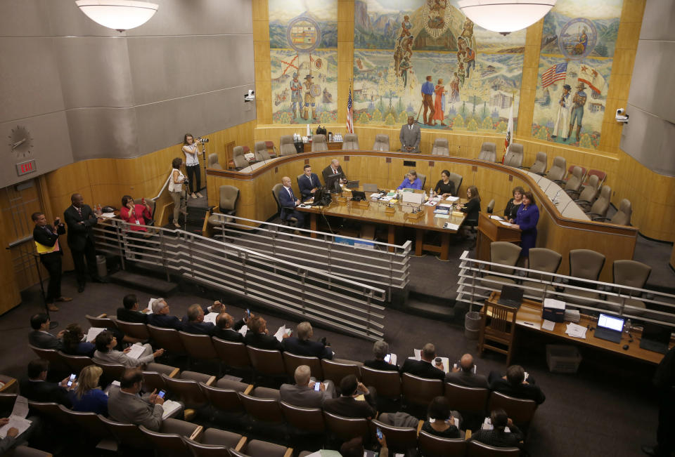 The California state Senate meet in one of the Senate committee rooms after a woman threw red liquid from the public gallery in the Senate chambers, in Sacramento, Calif., Friday, Sept. 13, 2019. The woman was taken into custody and with authorities investigating the substance thrown, Senate leadership decided to finish their work in the smaller committee room. Friday is the last day of this year's legislative session. (AP Photo/Rich Pedroncelli)