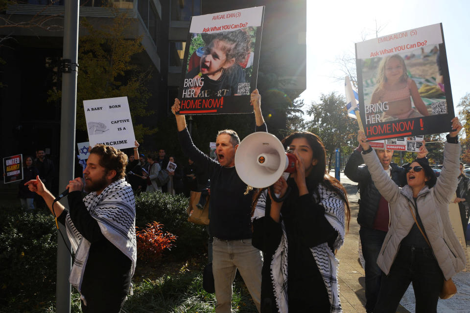 Protestors hold signs reading: A baby born captive is a warcrime and Ask what you can do, bring her home now!