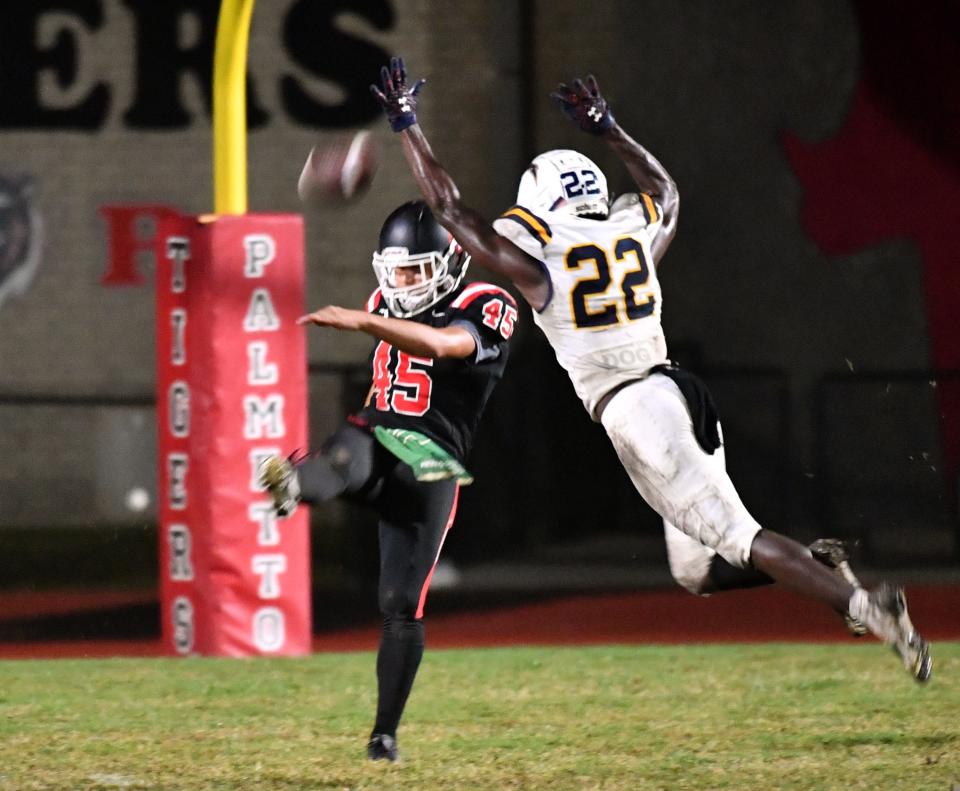 Lehigh's Robert Raybon (#22) blocks the kick by Palmetto punter Brandon Gonzalez (#45) in the second quarter, giving his team excellent field position. The Palmetto Tigers hosted the Lehigh Lightning in the FHSAA class 4S playoffs Friday night, Nov. 11, 2022. 