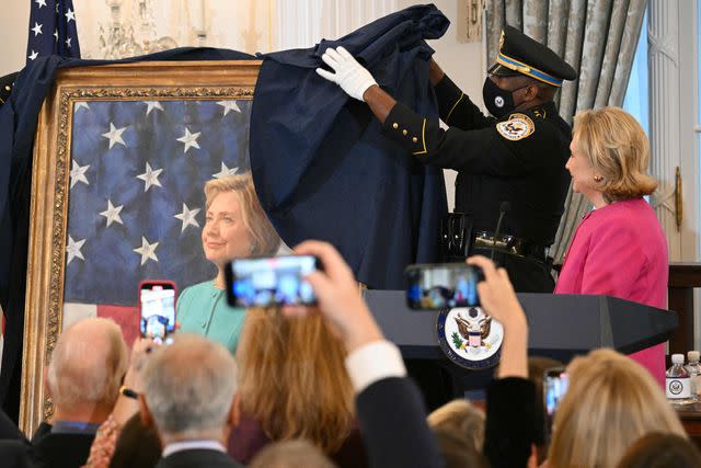 <p>MANDEL NGAN/AFP via Getty </p> Former Secretary of State Hillary Clinton watches as her portrait is unveiled in the Benjamin Franklin Room of the Truman Building on Sept. 26, 2023