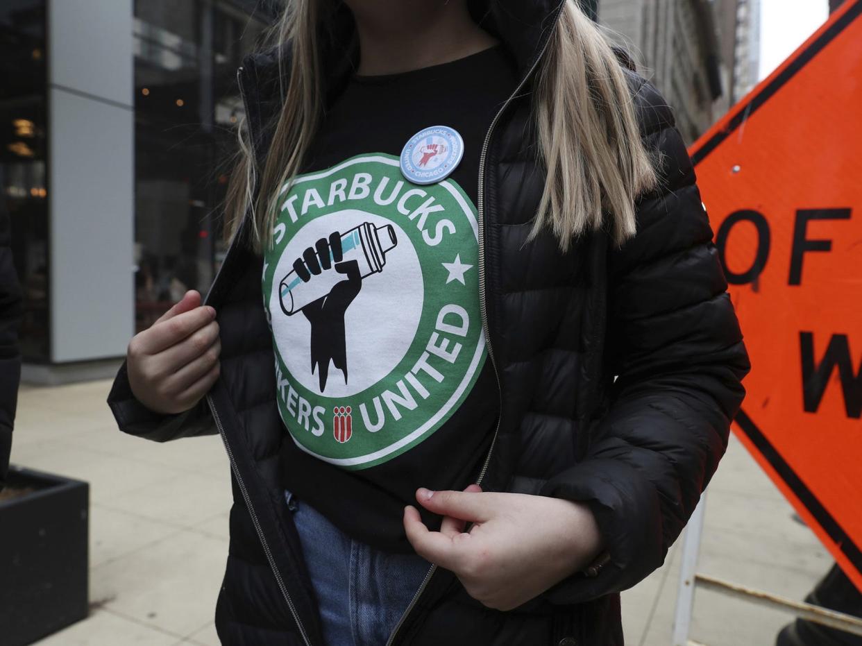 Starbucks workers wears a t-shirt and button promoting unionization.