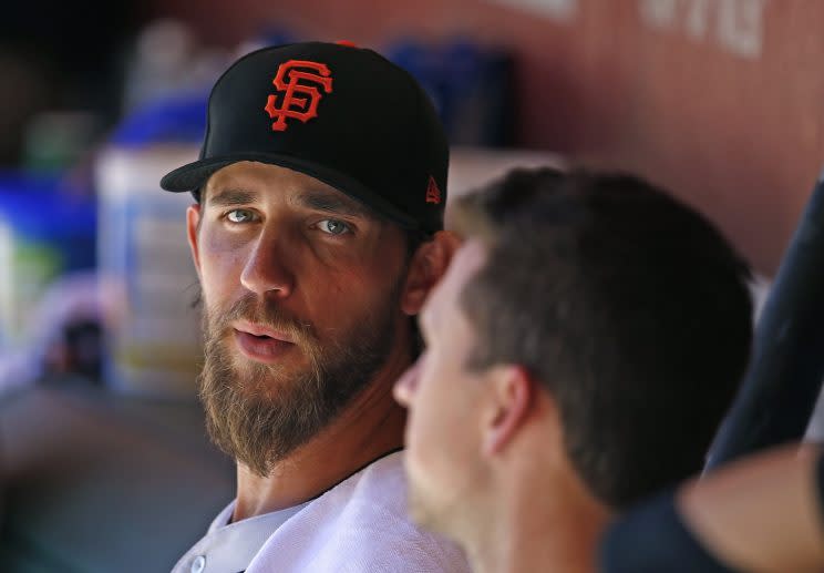 San Francisco Giants' Madison Bumgarner, left, talks with catcher Buster Posey, right, in the dugout during the fourth inning of an Opening Day baseball game against the Arizona Diamondbacks Sunday, April 2, 2017, in Phoenix. (AP Photo/Ross D. Franklin)