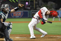 Los Angeles Angels' Jared Walsh, right, ducks out of the way of a close pitch caught by Seattle Mariners' Cal Raleigh during the sixth inning of a baseball game Friday, June 24, 2022, in Anaheim, Calif. (AP Photo/Mark J. Terrill)