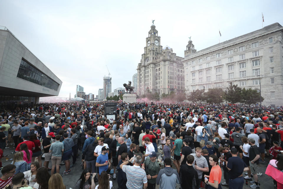 Liverpool soccer fans let off flares outside the Liver Building in Liverpool, England, Friday, June 26, 2020. Fans are being urged to celebrate the club's Premier League triumph at home as police believe more gatherings are planned after thousands filled the streets outside Anfield stadium. (Peter Byrne/PA via AP)