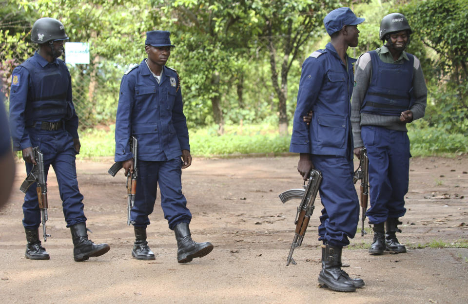 Armed police officers outside the residence of Evan Mawarire, an activist and pastor who helped mobilize people to protest against the hike in fuel prices, following his arrest in Harare, Zimbabwe, Wednesday, Jan. 16, 2019. Mawarire was arrested Wednesday for allegedly inciting violence in the protests against the government's increase in fuel prices. (AP Photo/Tsvangirayi Mukwazhi)