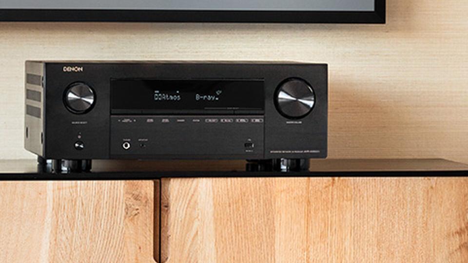 Denon A/V receiver sat on wooden unit