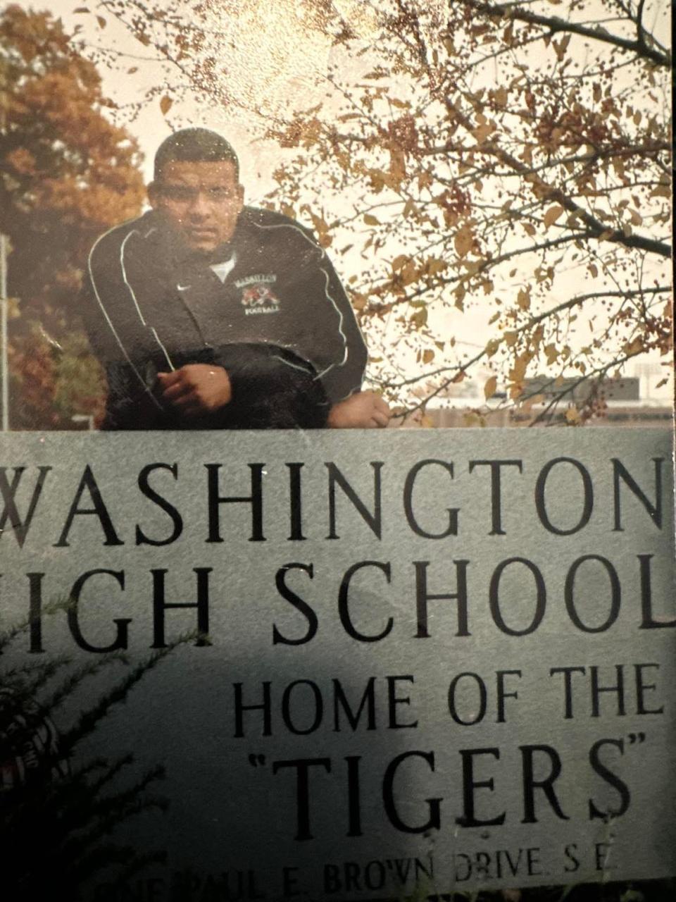 Dewayne Zimmerman stands on the Massillon Washington High School sign in his Tigers jacket. Zimmerman graduated in 2005.