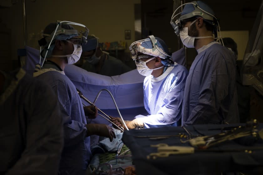 FILE - In this Tuesday, Jan. 23, 2018 file photo, a doctor, center, directs a special camera to look at a patient's tumor at a hospital in Philadelphia. According to research released on Wednesday, May 13, 2020, cancer deaths have dropped more in states that expanded Medicaid coverage under the Affordable Care Act than in states that did not. (AP Photo/Matt Rourke)