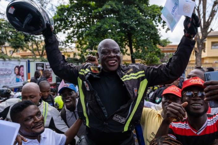 Kunle Adeyanju (C) celebrates with supporters after arriving at the Ikeja Rotary club in Lagos on May 29, 2022, after a 41 day trip from London, by motorbike, to raise funds and awareness for the End Polio campaign.